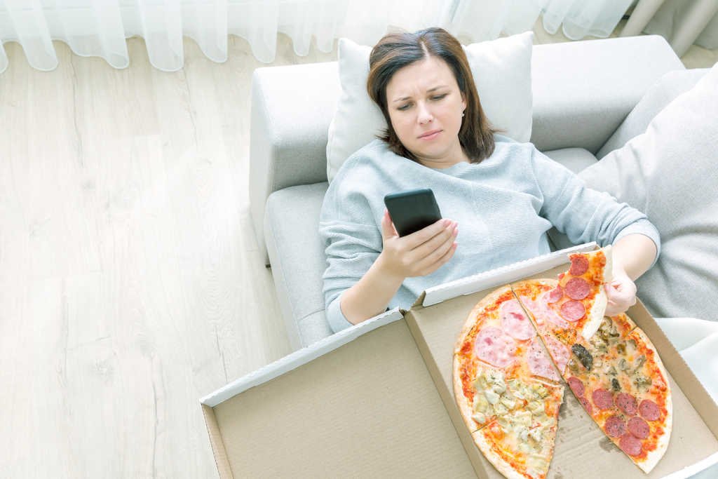 woman stress eating pizza